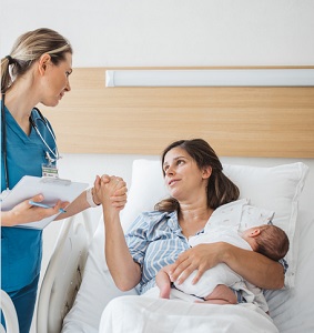 New Mom holding new born and talking to doctor