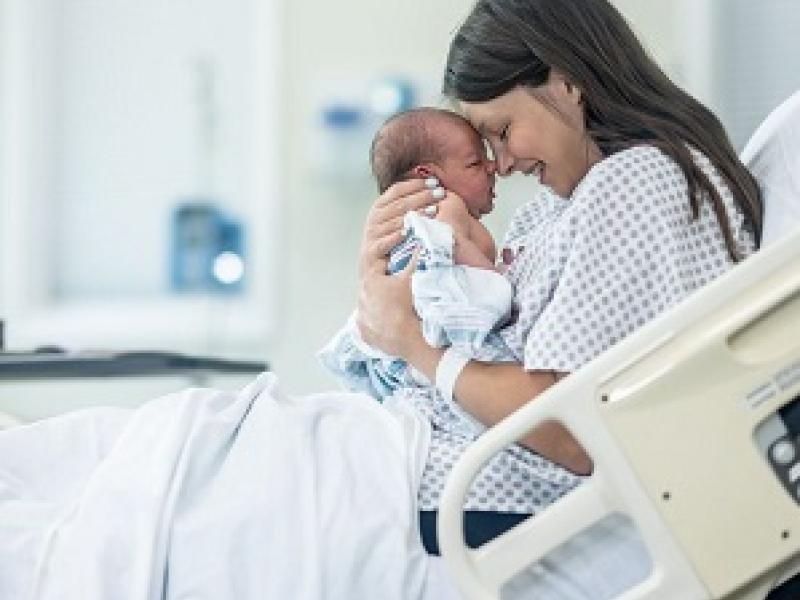Mom holding newly born baby in hospital