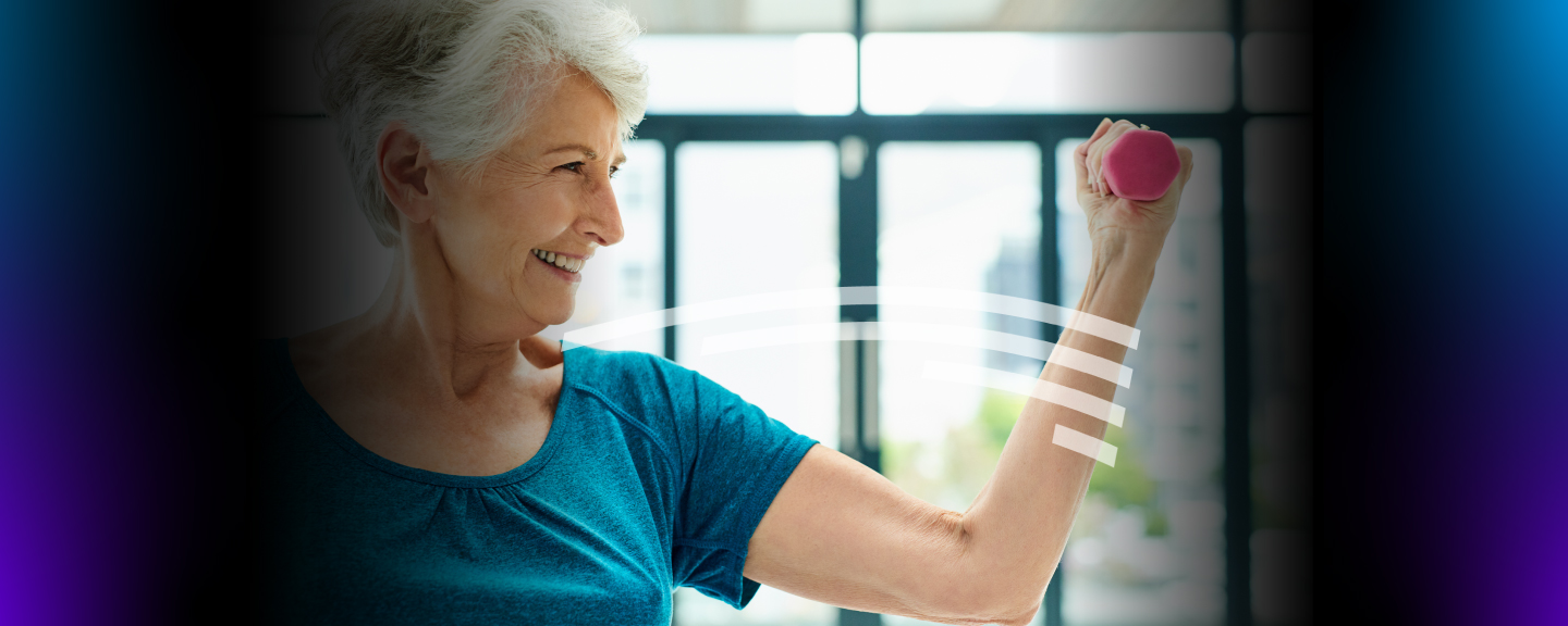 older woman smiling while lifting a weight