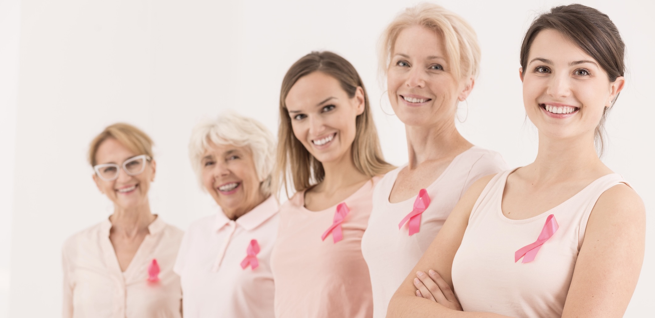 5 women wearing breast cancer awareness ribbons