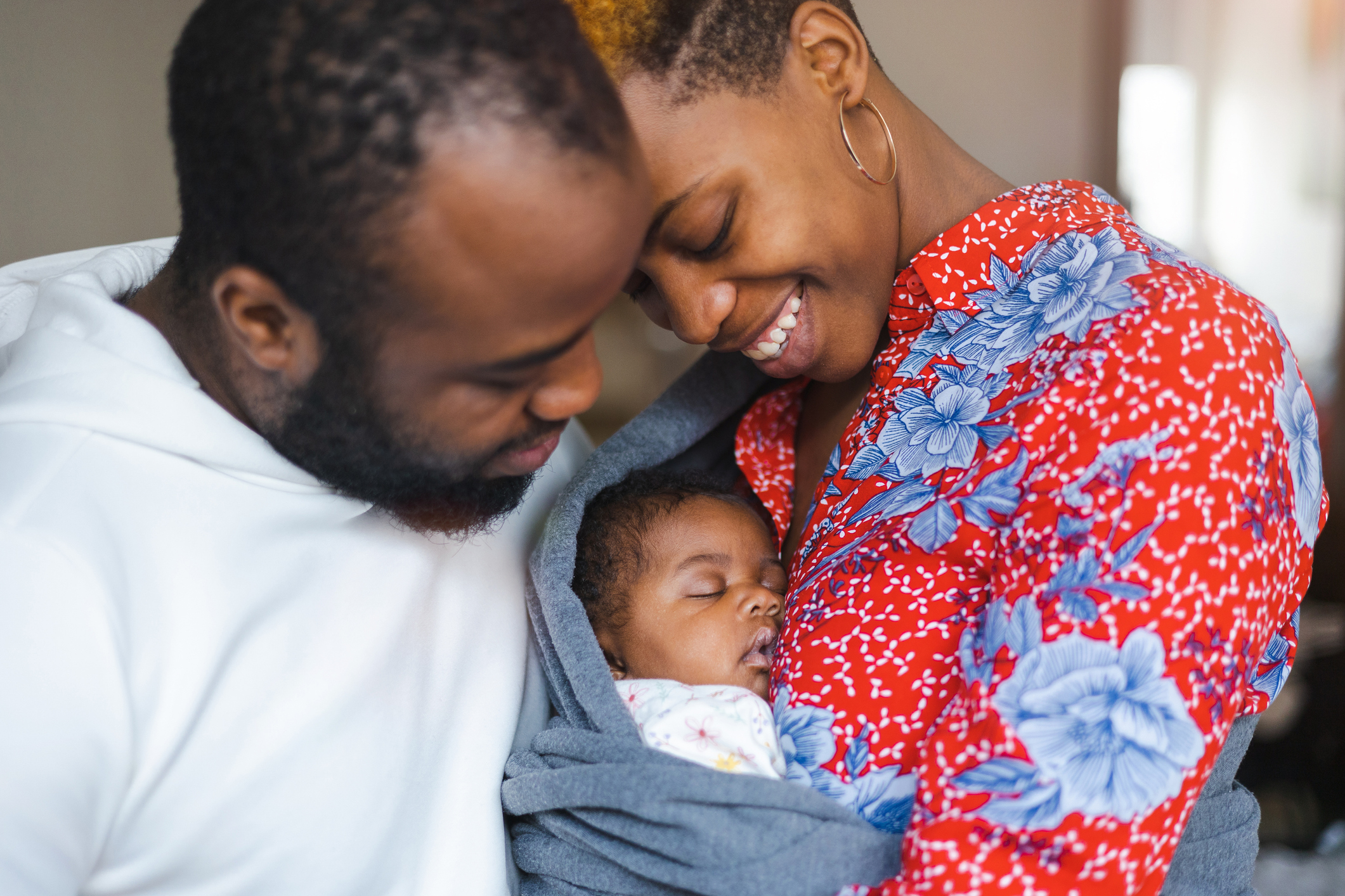 Two parents holding a newborn child