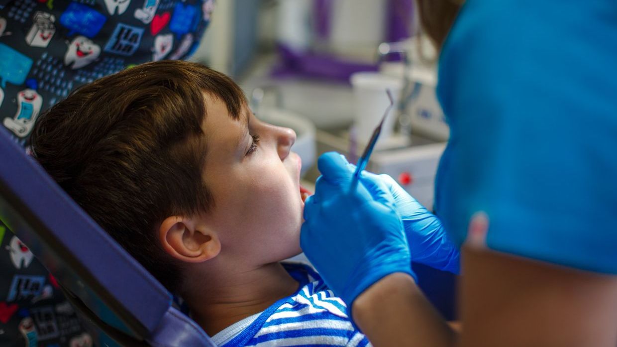 Doctor checking inside boy's mouth 