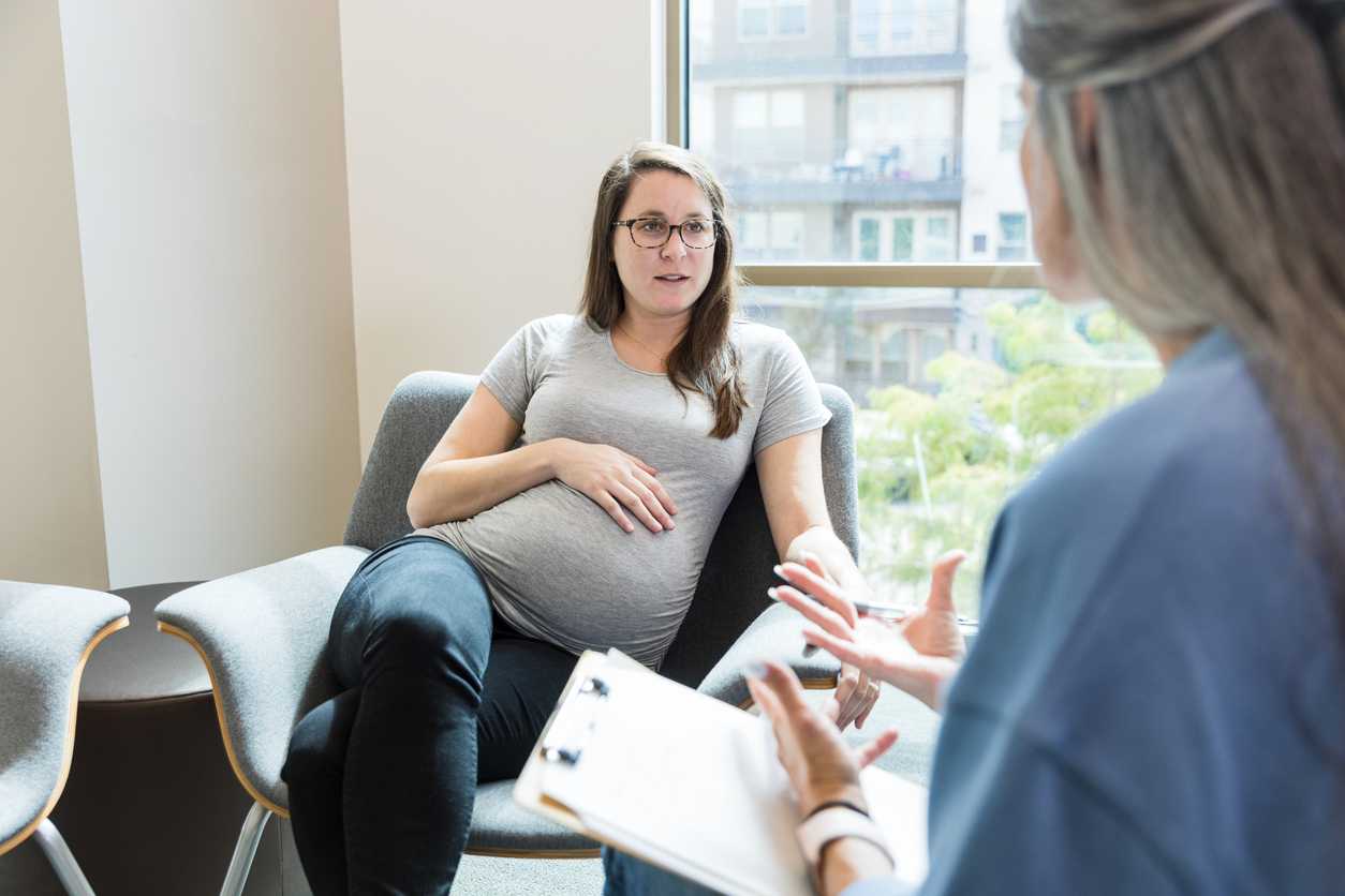 Pregnant woman taking to female doctor