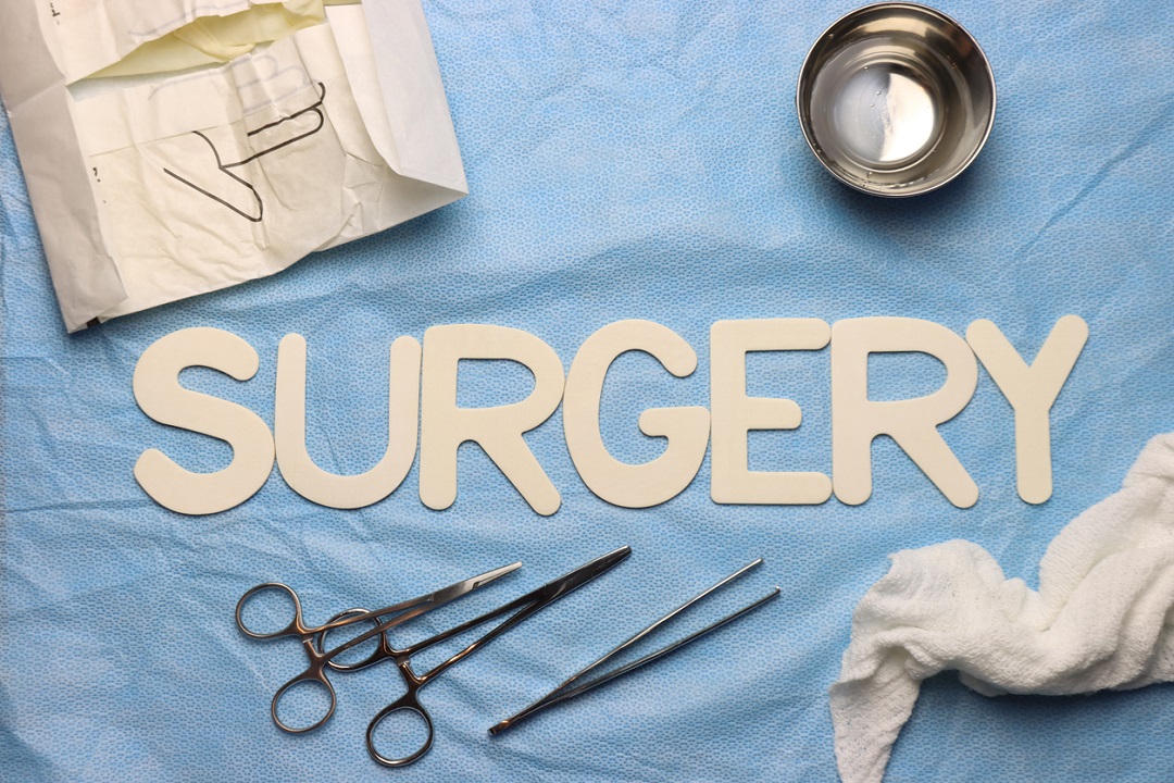 Word "surgery" with scissors and towel