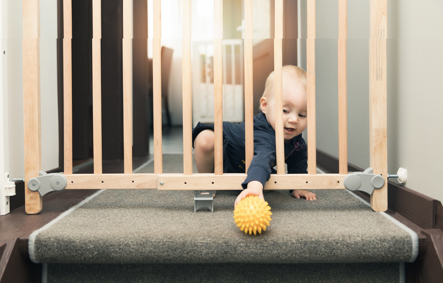 An Infant playing with ball near stairs 