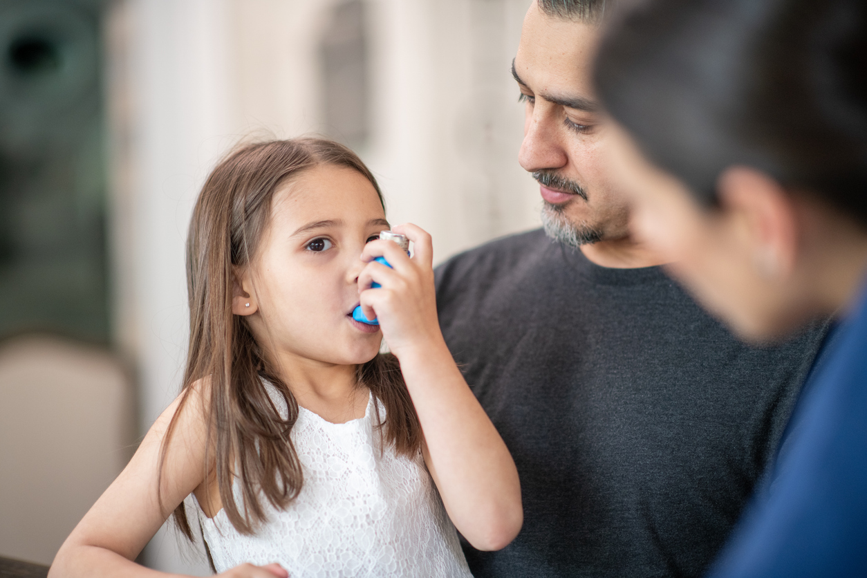 Young girl with Asthma issues using breathing inhaler