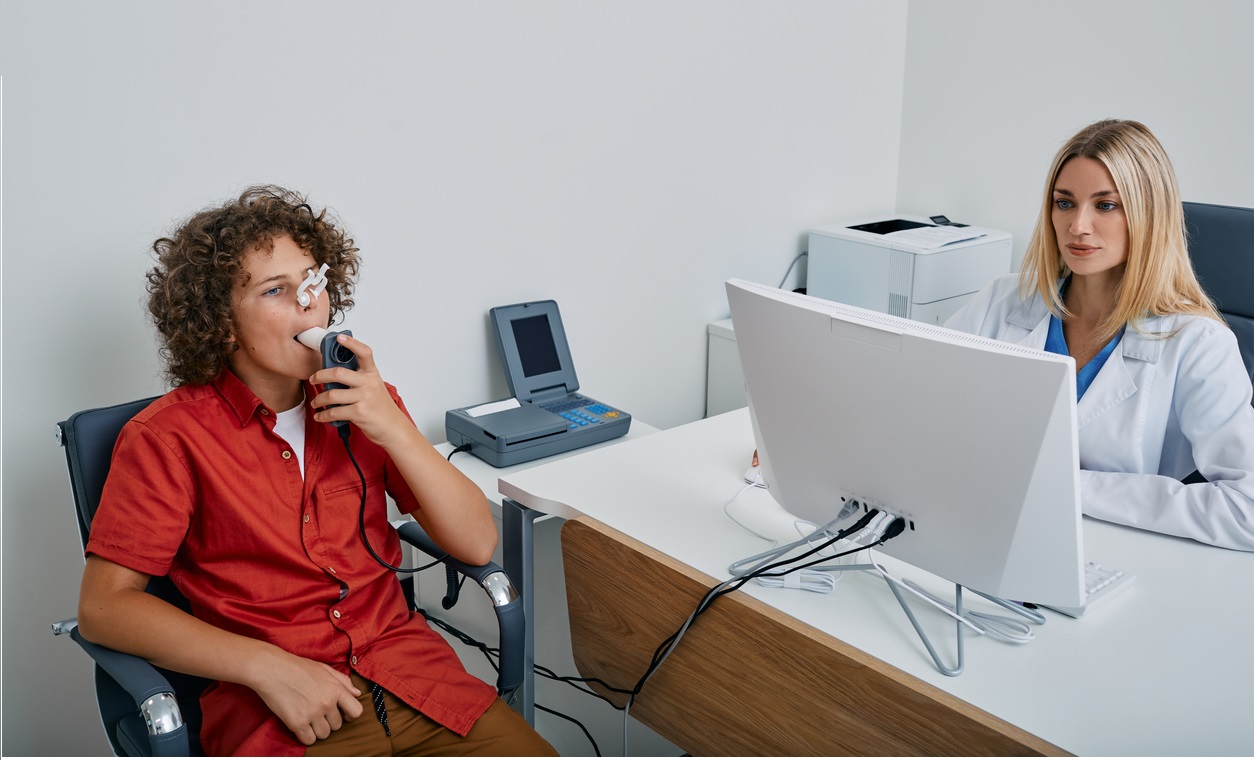 Young boy taking lung function test under doctor's supervision