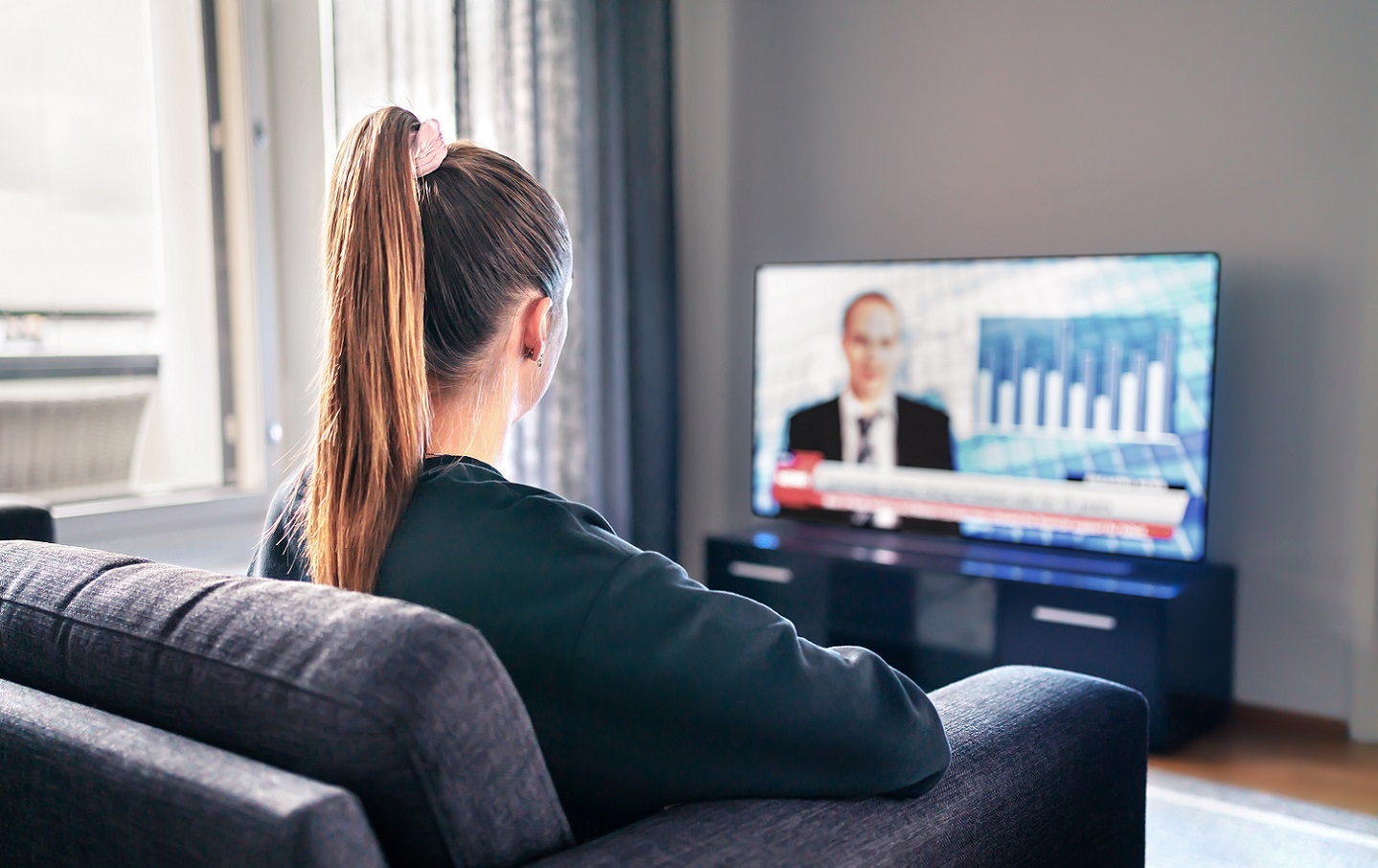 Young girl watching news on TV