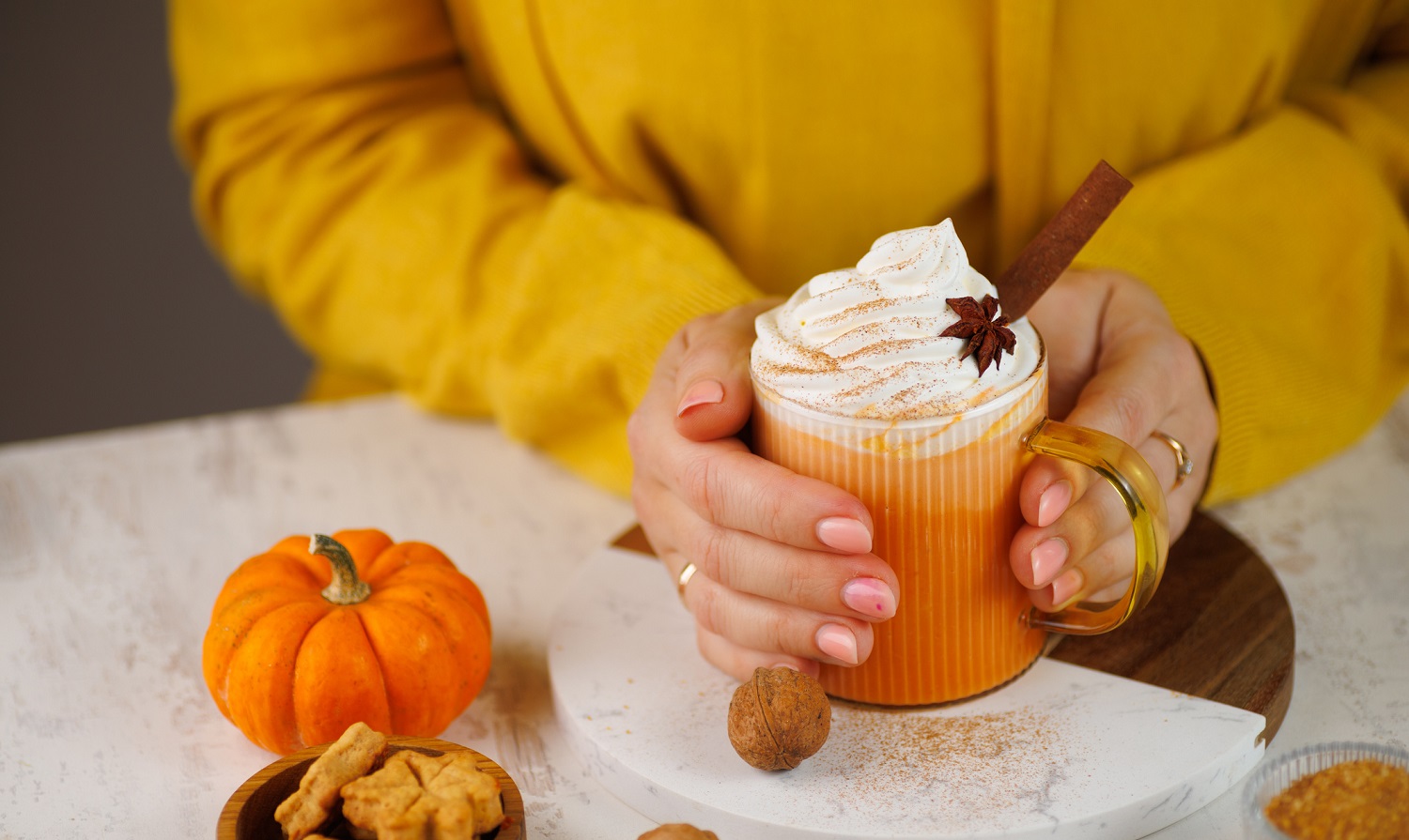 Woman holding pumpkin spice latte drink