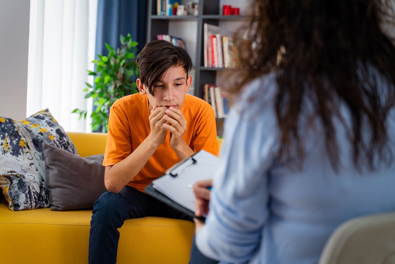 Young boy sitting on a couch talking to psychiatrist