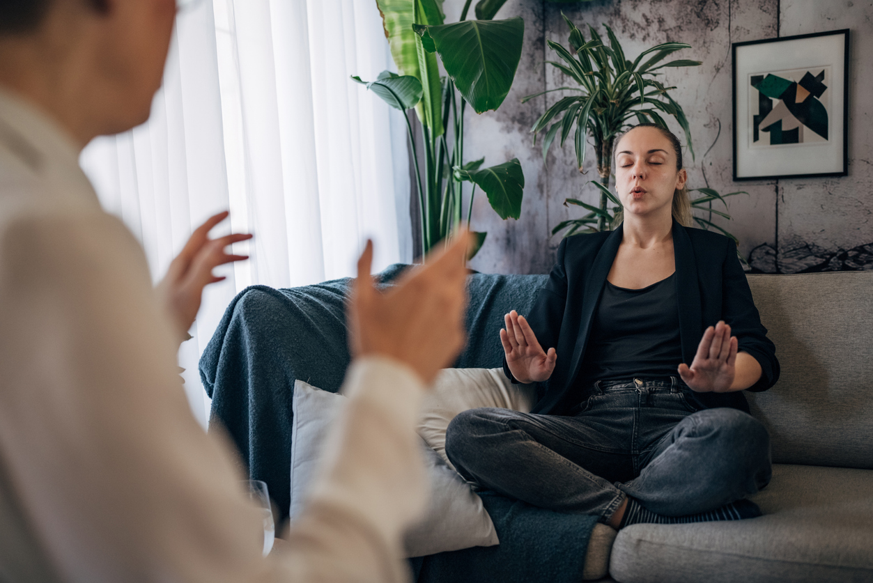 young woman taking deep breaths during psychiatric session 