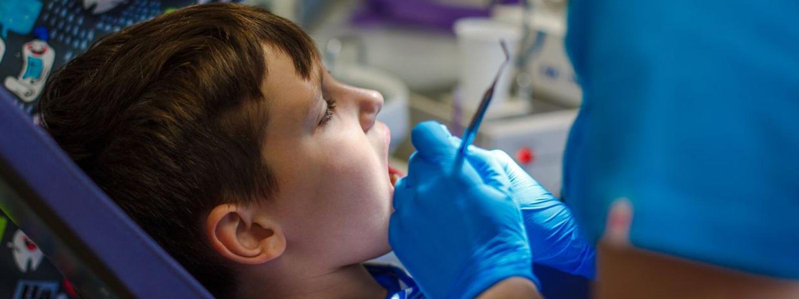 Doctor checking inside boy's mouth 