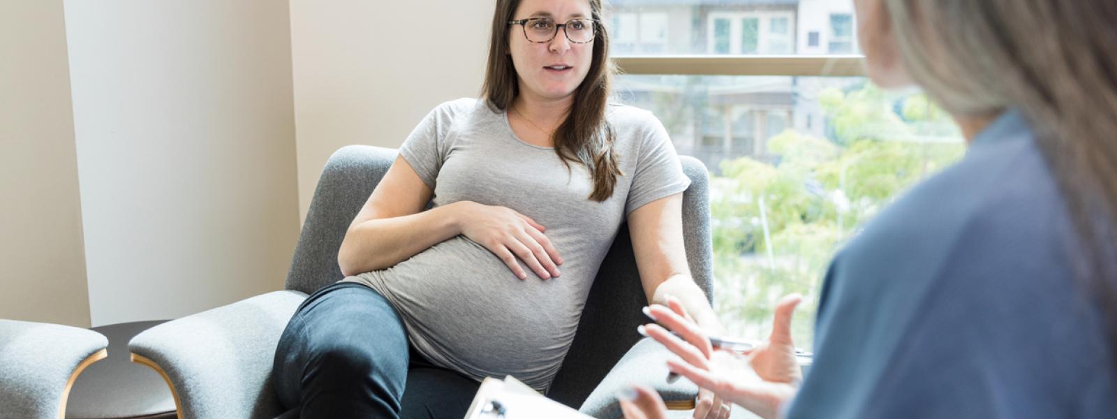 Pregnant woman taking to female doctor