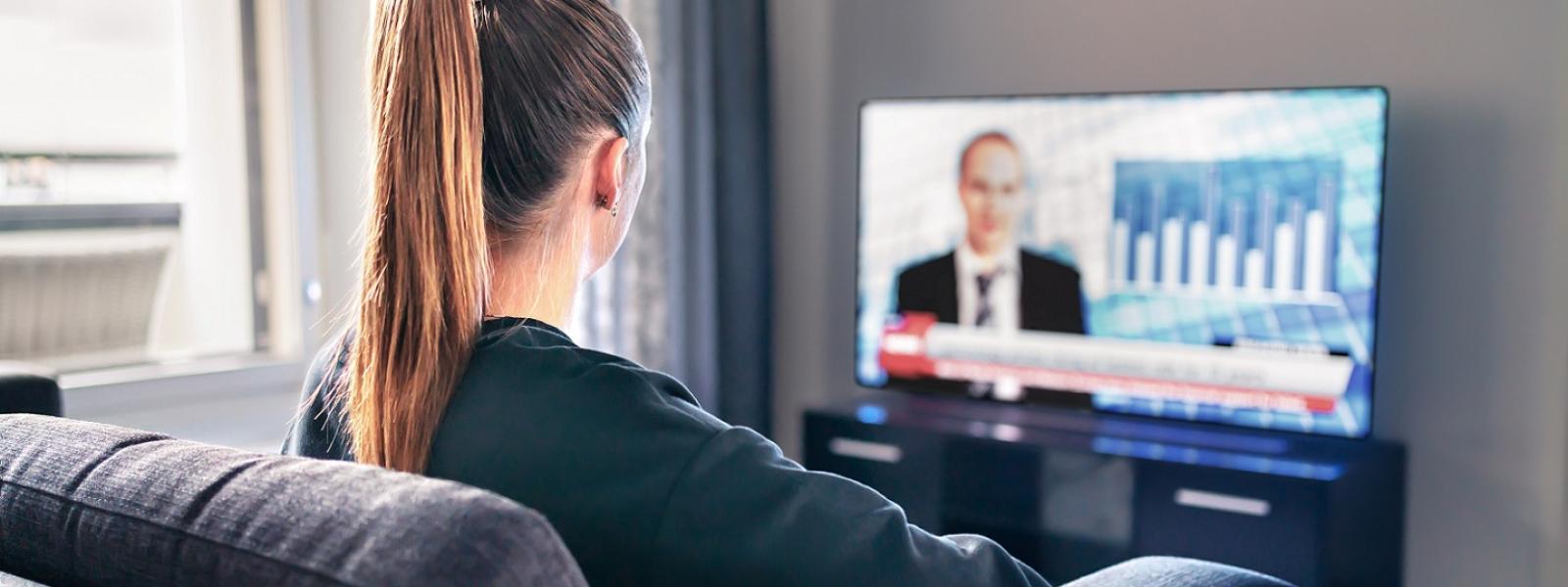 Young girl watching news on TV