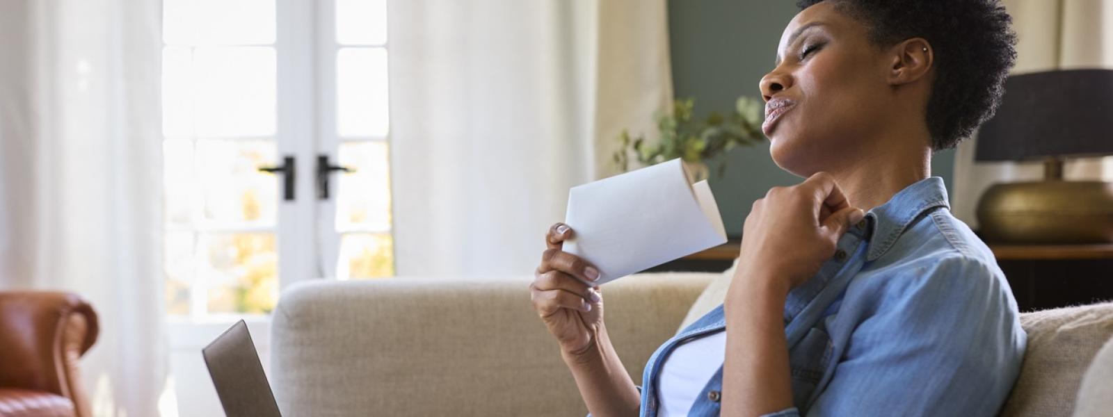 woman fanning herself with paper