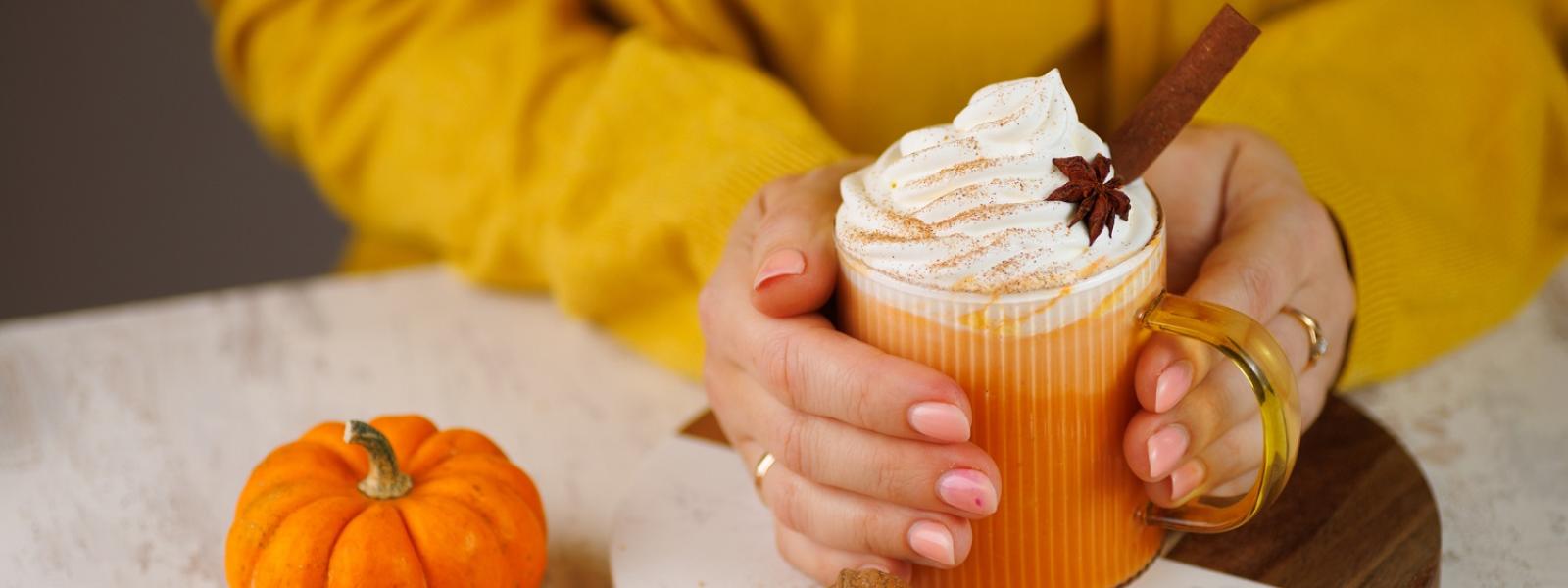 Woman holding pumpkin spice latte drink