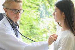 Doctor checking female patients heart beat