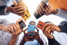 Teens in circle holding smart phones