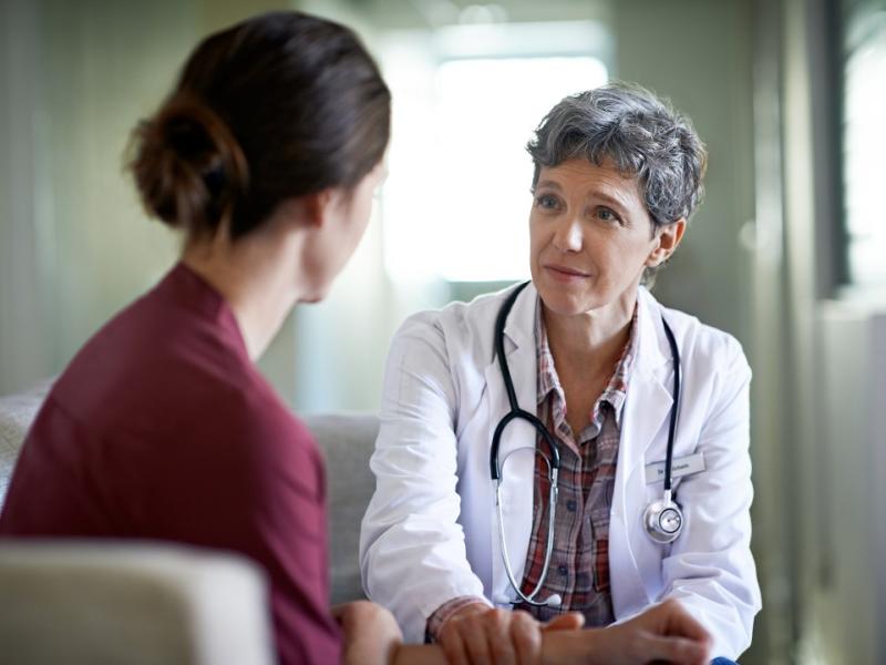 Female Doctor Talking to Patient and Holding Her Hand