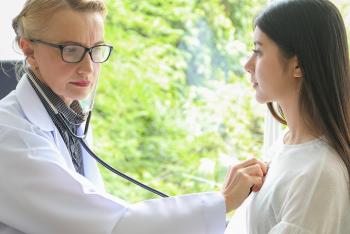 Doctor checking female patients heart beat