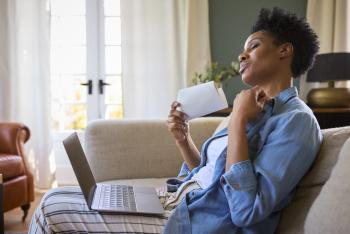 woman fanning herself with paper