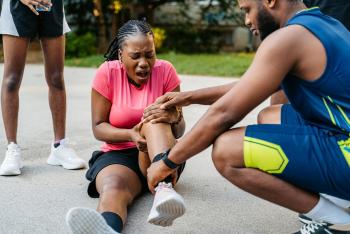 Sports therapist checking injured athlete 