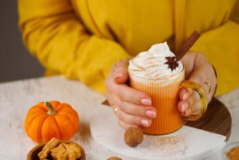 Woman holding pumpkin spice latte drink