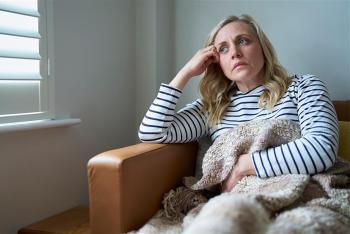 Woman with hand on head in chair