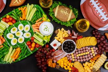 Football game day themed party snack platters on a decorated table.