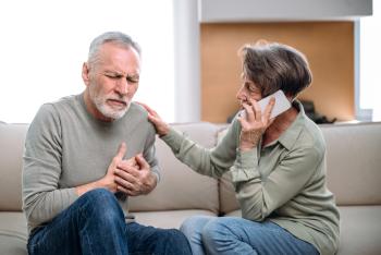 Elder couple sitting on couch. Man experiencing heart pain.